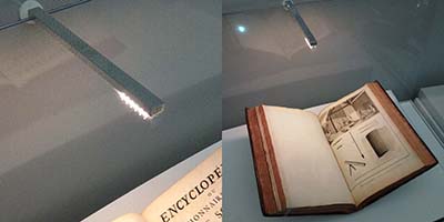 Custom aluminum light fixture shines light on a rare book inside a museum displaycase